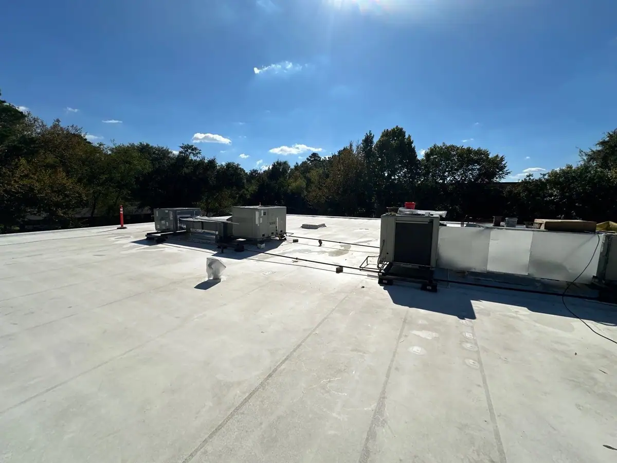 Finished white TPO flat roof under a clear sky, commercial roofing by Dickerson Contracting serving Pearl, MS