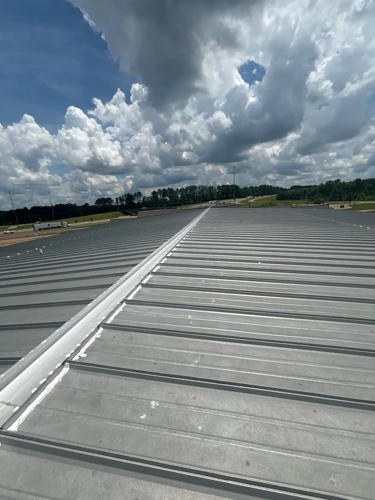 Finished metal roof ridge on a long commercial building, metal roofing by Dickerson Contracting serving Pearl, MS