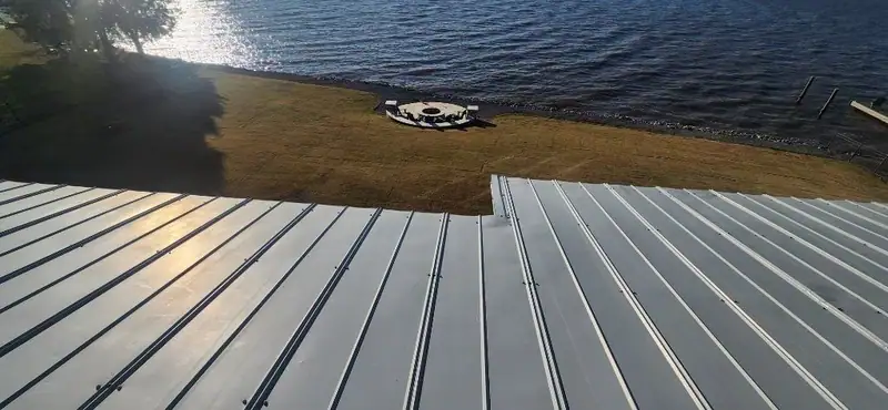 Standing seam metal roof above a lakefront yard, metal roofing by Dickerson Contracting serving Pearl, MS