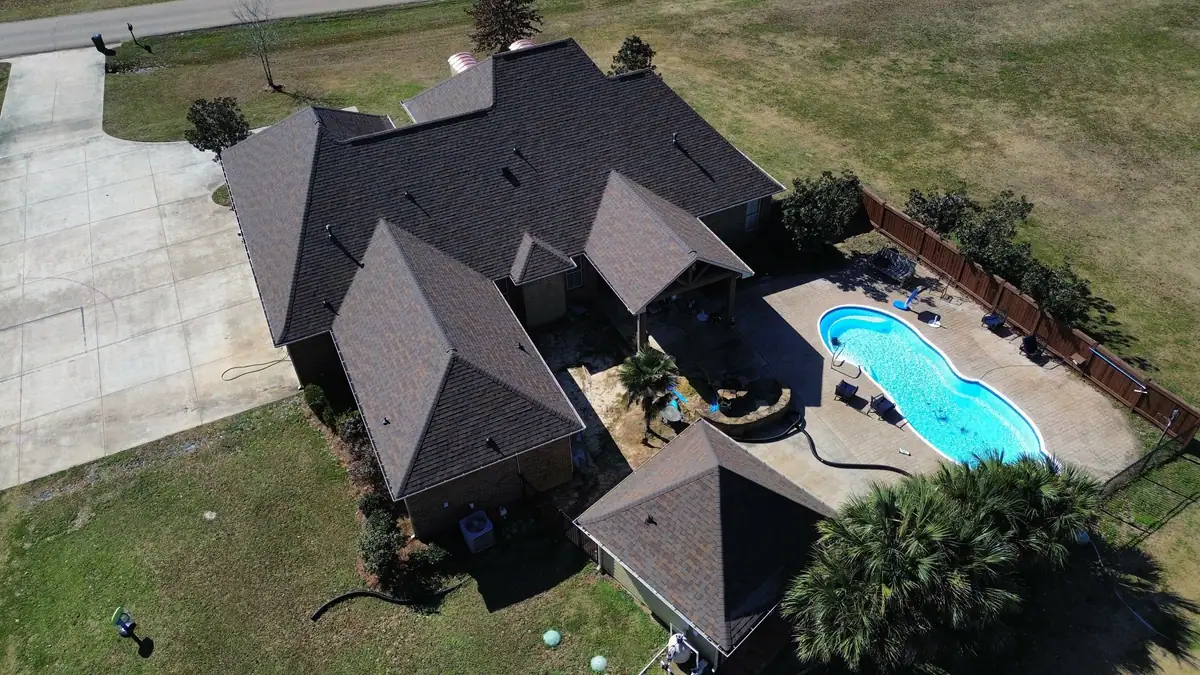Home with a new shingle roof and a backyard pool, residential roofing by Dickerson Contracting serving Pearl, MS