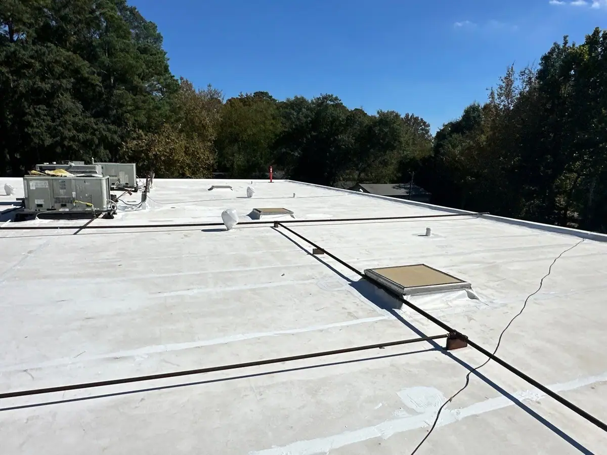 Finished white flat roof with a skylight and conduit runs, commercial roofing by Dickerson Contracting serving Ridgeland, MS