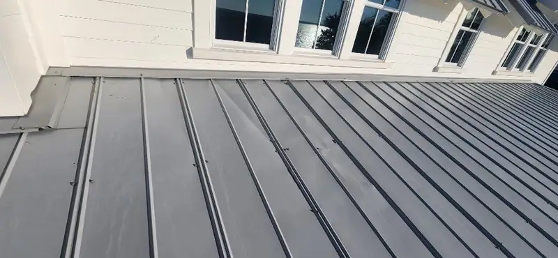 New standing seam metal roof panels against white siding, metal roofing by Dickerson Contracting serving Ridgeland, MS
