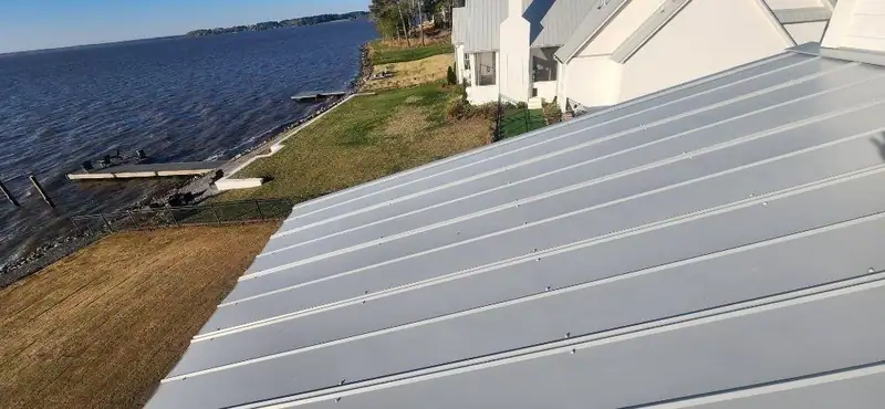 Standing seam metal roof running down to a lakefront lawn, metal roofing by Dickerson Contracting serving Ridgeland, MS